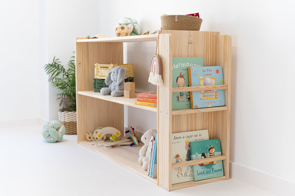 Estantería con librería Montessori de madera natural, diseñada para facilitar el acceso de los niños a sus libros y juguetes.